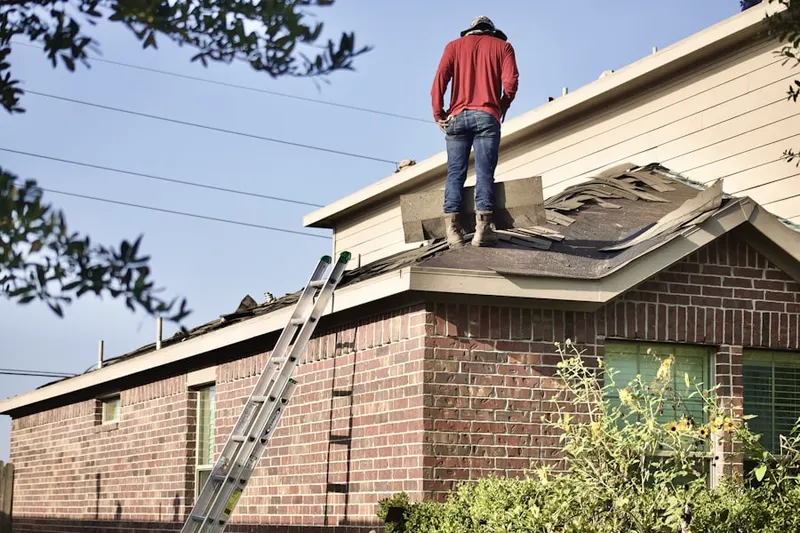 Professional roofer working on a residential roof in Raisin City